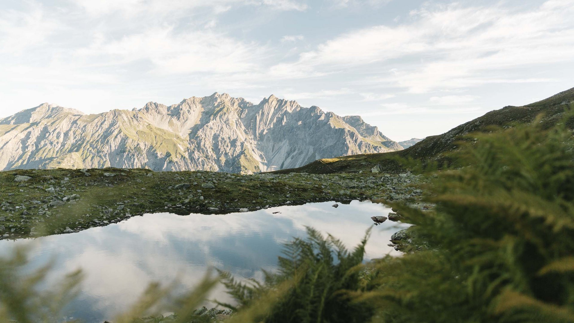 Berglandschaft mit See, der die Wolken und Berge reflektiert