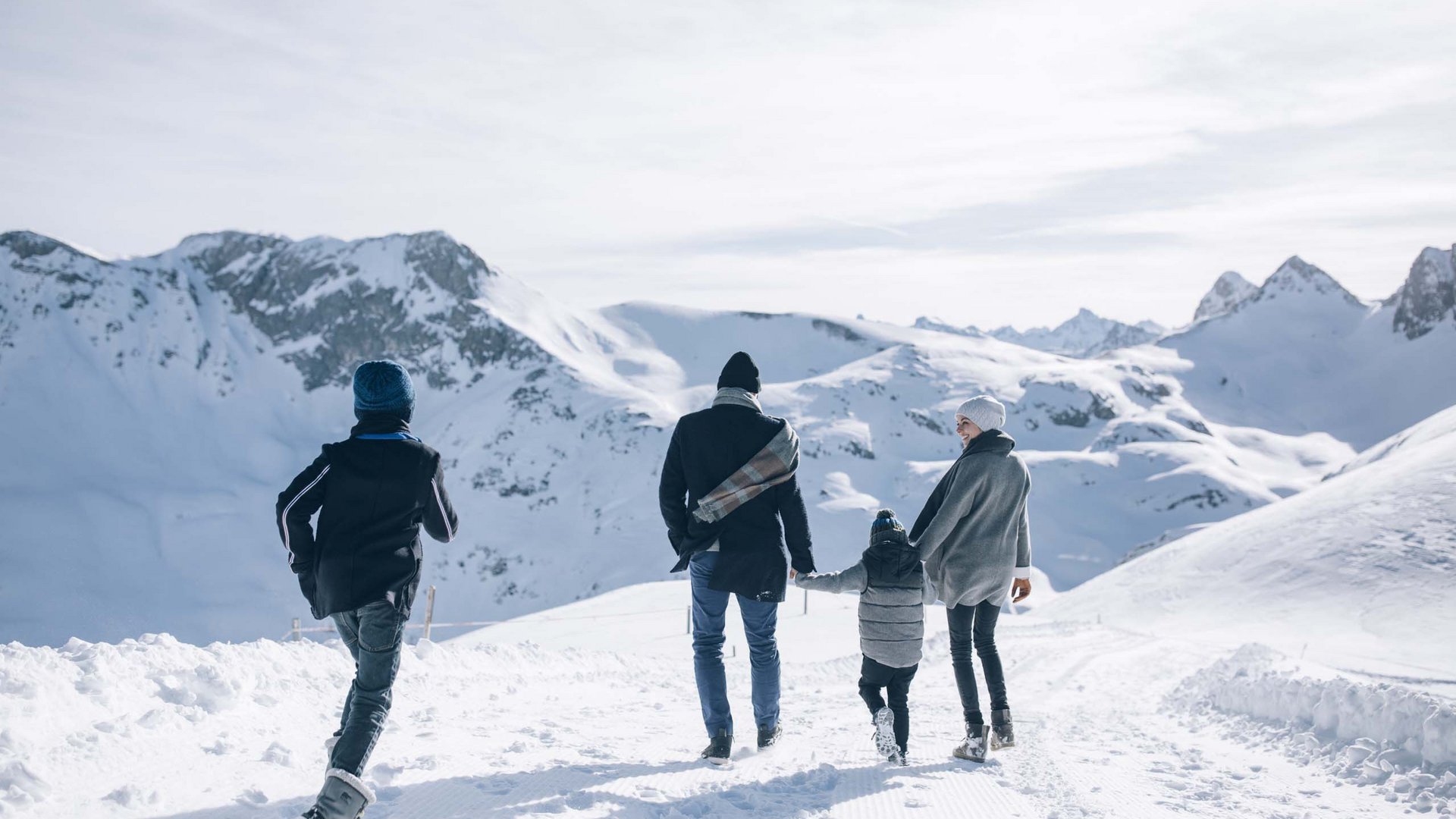 Familie wandert im Schnee mit Bergblick