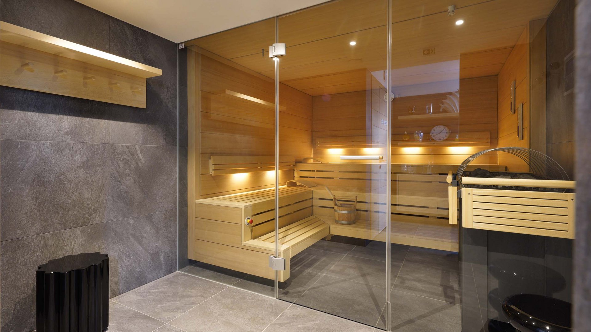 Moderner Saunaraum mit Glaswand und Holzbänken